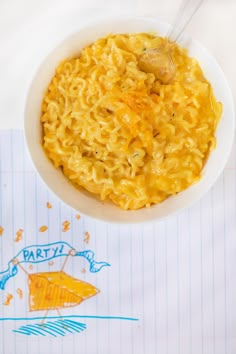 a white bowl filled with macaroni and cheese on top of a notepad