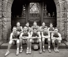 a group of men sitting next to each other in front of a building