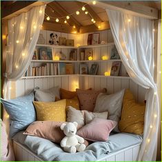 a bed with lots of pillows on top of it and lights hanging from the ceiling