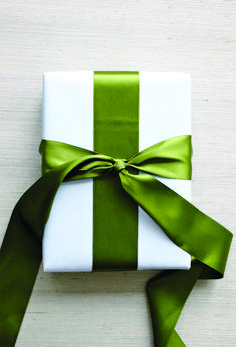 a present wrapped in white and green ribbon