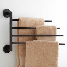 three towels are hanging on the wall next to a towel rack with two black bars