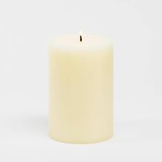 a white pillar candle with a single flame