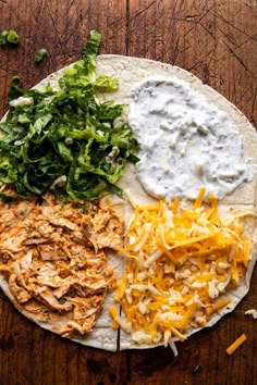 a tortilla topped with cheese, lettuce and other toppings