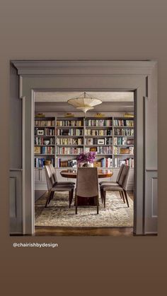 a dining room table and chairs with bookshelves in the background