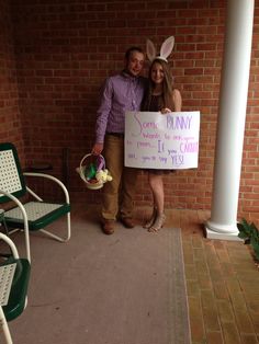 a man and woman standing next to each other holding signs