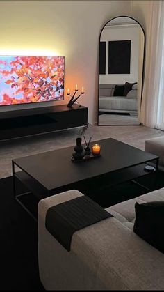 a living room filled with furniture and a large flat screen tv mounted on the wall