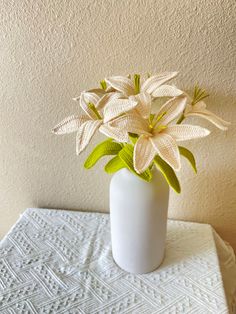 a white vase filled with flowers on top of a table