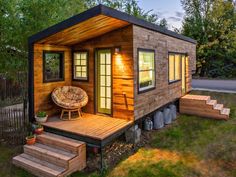 a tiny house built into the side of a grassy area with steps leading up to it