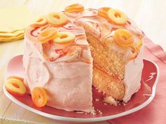 a cake with white frosting and fruit toppings on a plate next to a fork