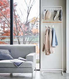 a living room scene with focus on the sofa and coat rack in the foreground