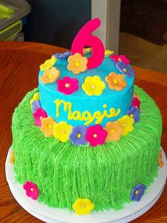 a birthday cake decorated with grass and flowers for a child's 5th birthday party