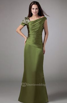 a woman in a long green dress posing for the camera with her hands on her hips