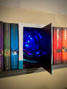 a book shelf with several books on it and a blue light in the middle one