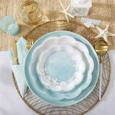 a table setting with plates, silverware and starfish napkins on the plate rack