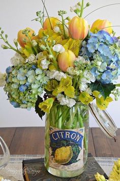 a vase filled with flowers sitting on top of a wooden table next to a book