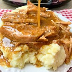 a plate topped with mashed potatoes covered in gravy next to an instant pot roaster