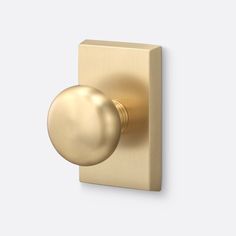 a gold door knob on a white wall with a round ball in the center and an oval