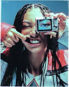 a woman with dreadlocks holding up a camera