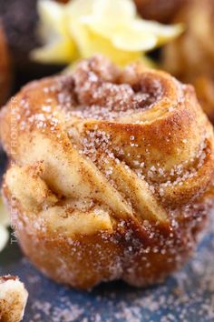 a pastry with powdered sugar on it sitting on a blue surface next to other pastries