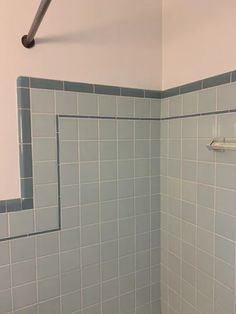 a white toilet sitting in a bathroom next to a bath tub with blue tiles on the walls