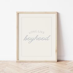 a white framed poster with the words long live boyhood in blue ink on it