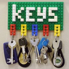 there is a lego key holder with keys hanging on the pegs in front of it