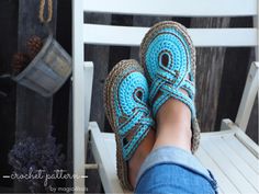 someone wearing crocheted slippers sitting on a chair with their feet propped up