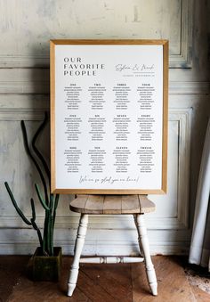 a seating chart on a wooden chair next to a potted plant