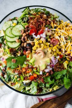 a salad in a glass bowl with dressing on top