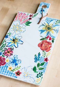 a cutting board with flowers painted on it