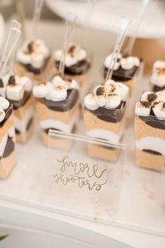 cupcakes with marshmallows and chocolate toppings are arranged on a table