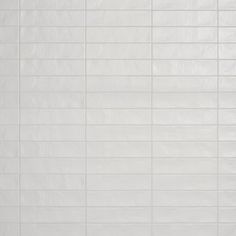 a white tiled wall and floor with no one in the room or someone standing on it