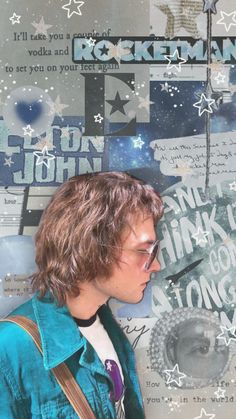 a young man with glasses is standing in front of a wall that has stars on it