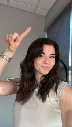 a woman is making the peace sign with her hand