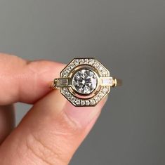 a person is holding a ring in their hand with diamonds on the sides and inside