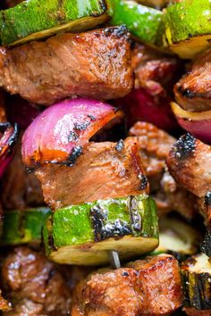 meat and vegetables being cooked on skewers