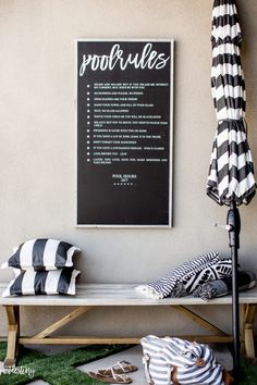 a black and white striped umbrella sitting on top of a wooden bench next to a sign