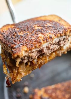 a grilled cheese sandwich being held up by a fork