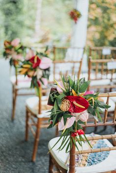 the chairs are decorated with flowers and greenery