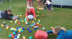 two children playing with balls in the grass