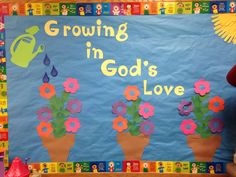 a bulletin board that says growing in god's love with flowers and watering can