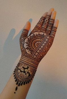 a woman's hand with henna on it and the bottom half of her arm