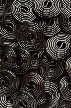 many rolls of black and white paper are stacked on top of each other in the shape of spirals