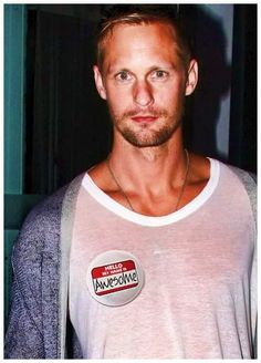 a man wearing a white shirt with a badge on it's chest is looking at the camera