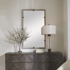 a large mirror sitting on top of a dresser next to a lamp