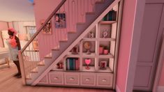 a woman standing in front of a pink book shelf next to a stair case filled with books