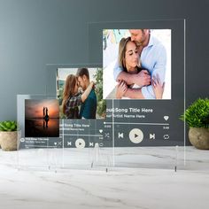 three clear acrylic frames with photos on them and a succulent plant