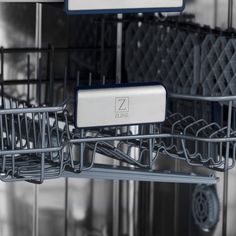 an empty dishwasher with the door open and two metal baskets in front of it