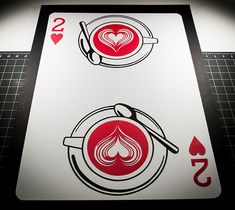 two playing cards with hearts and spoons on them