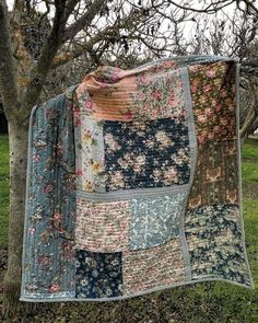 a patchwork quilt hanging from a tree